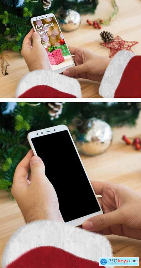 Christmas Themed Hands Holding a Smartphone Mockup 301234767