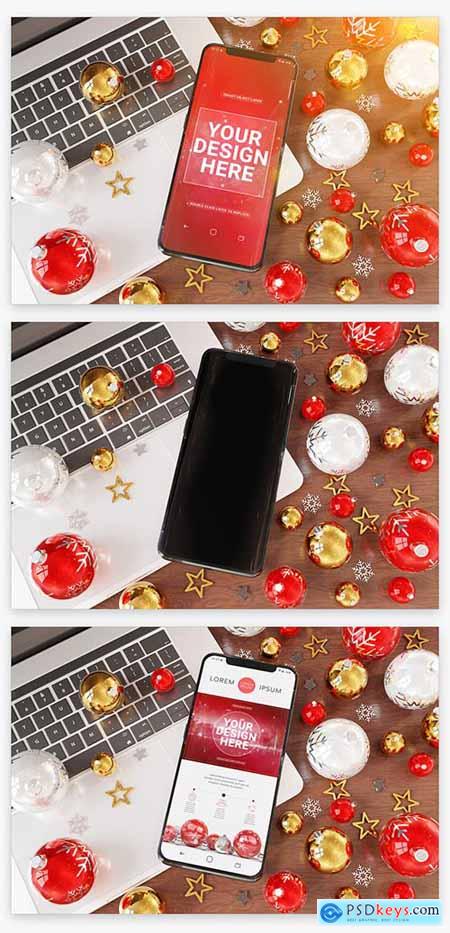Mobile Phone Laying on a Laptop near Christmas Ornaments Mockup 222832498
