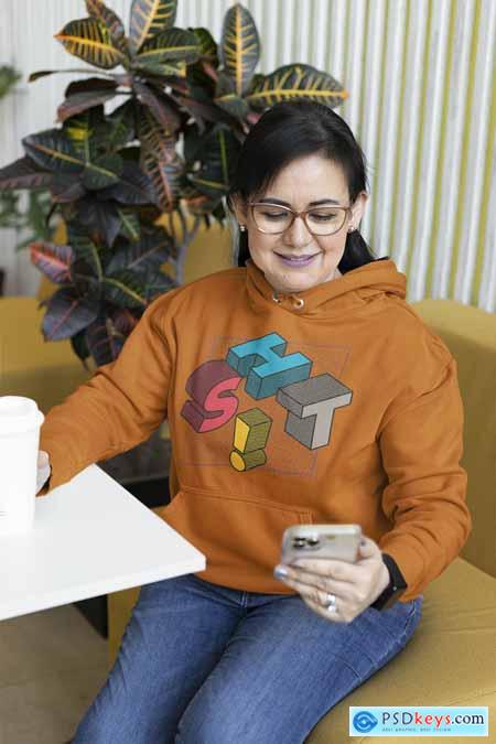 Hoodie Mockup of a Woman Checking Her Smartphone